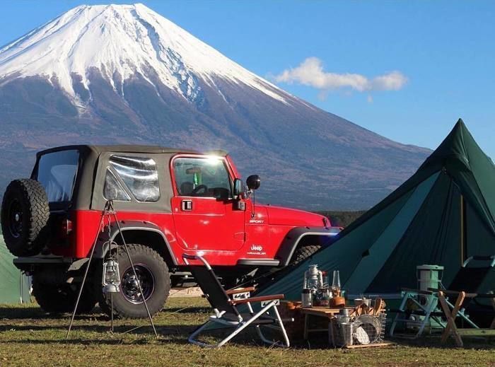 赤いジープと緑のテント