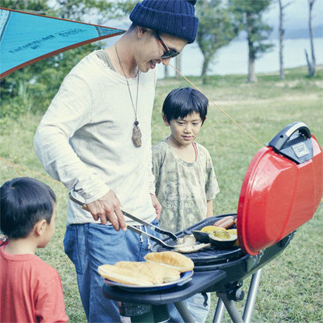 父親と子供がグリルでバーベキューをしている