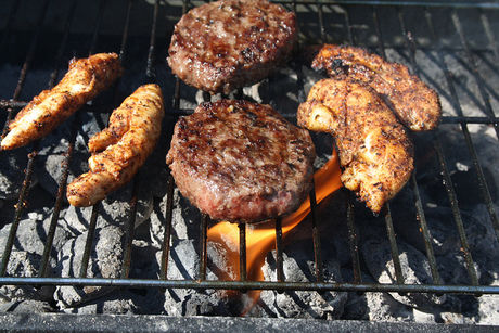 バーベキューで焼かれているハンバーグと肉