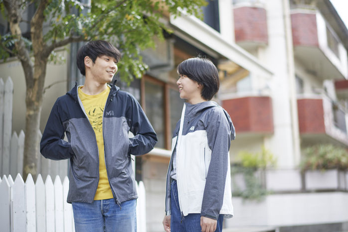 ミレーのジャケットを着て会話をしている男女