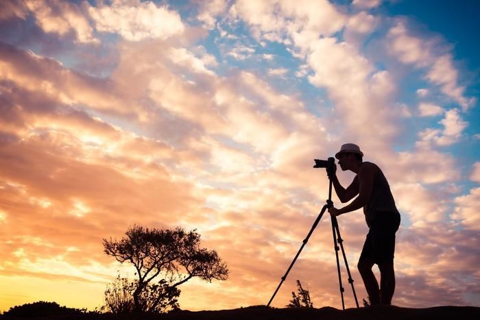 夕暮れの中写真を撮る男性