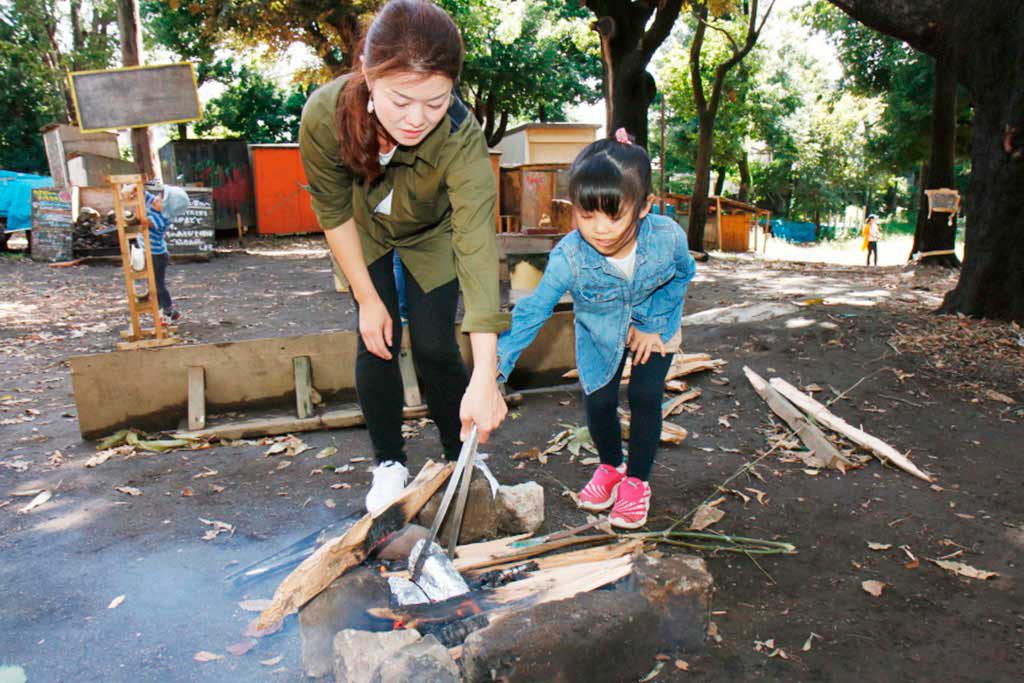 たき火の中にさつまいもを投入/羽根木プレーパーク(東京都/世田谷区)