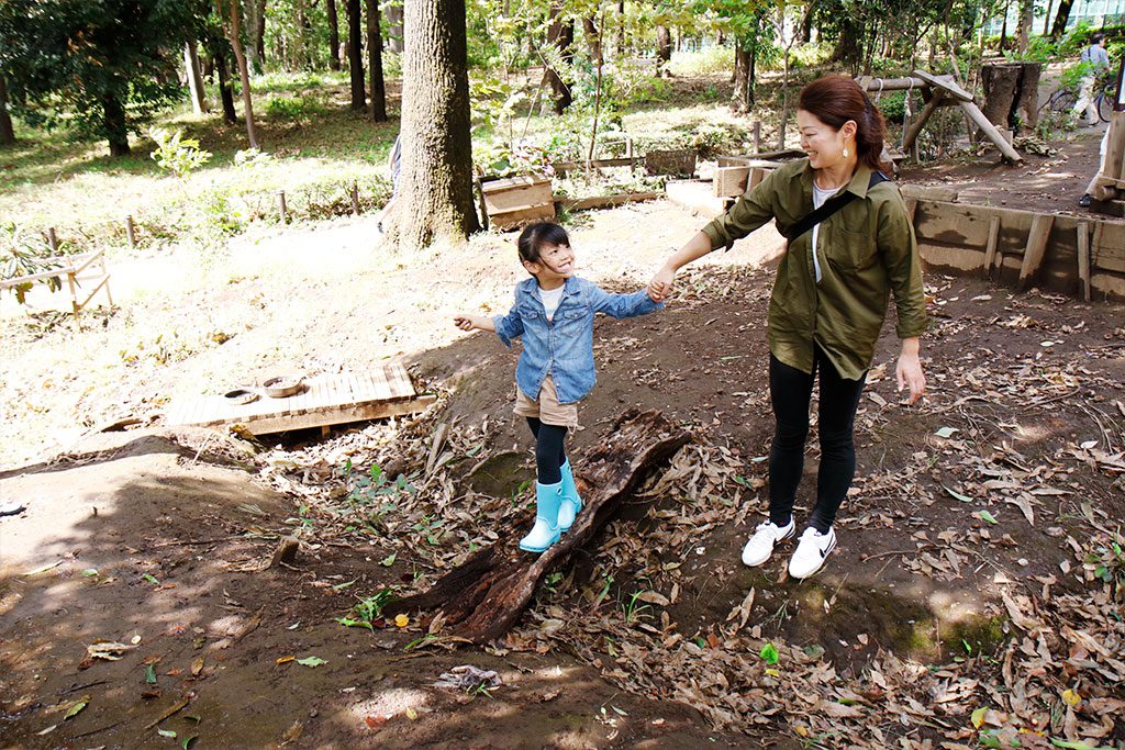 でこぼこ道を手を繋いで歩く親子/羽根木プレーパーク(東京都/世田谷区)