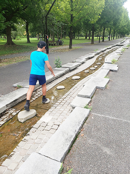 せせらぎの石の上を渡り歩く子ども/舎人公園(東京都/足立区)