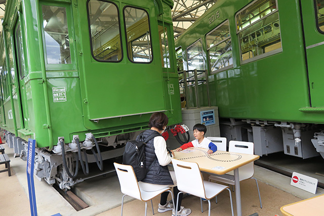 車両脇に置かれたテーブルで食事する親子/京王れーるランド(東京都/日野市)