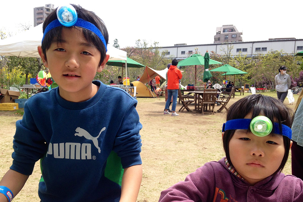 防災キャンプ:手作りヘッドライトをつける子ども