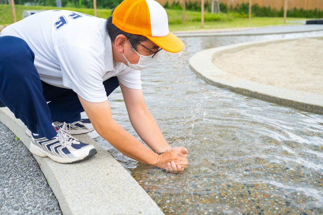 手で水鉄砲を作って遊ぶスタッフの木村さん/生駒山上遊園地(奈良県/生駒市)
