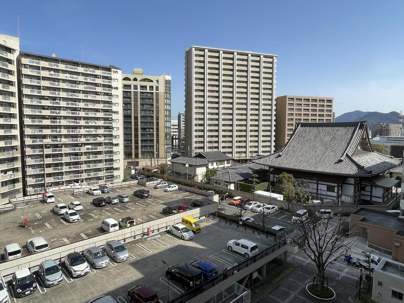北九州市小倉北区大手町の売買物件/手前は駐車場で開けています。お寺も見えます。