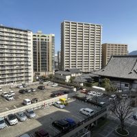 北九州市小倉北区大手町の売買物件/手前は駐車場で開けています。お寺も見えます。