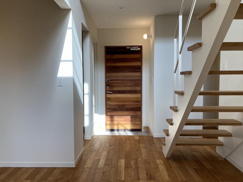 鎌倉市津の賃貸物件/1階 玄関｜板張りが特徴の扉を開けた先は、吹き抜けの空間と階段
