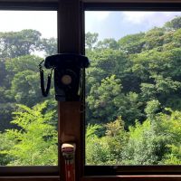 鎌倉市大町六丁目の売買物件/2階廊下｜連続する腰窓からの眺望が素晴らしい。柱に取り付けられた黒電話がノスタルジー。