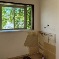 葉山町堀内の売買物件/洗面室｜以前の洗面化粧台の跡が見えます。窓にはツタが覆っています。