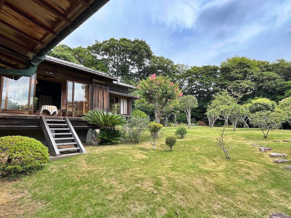 葉山町上山口の売買物件/庭から北側8畳を見る｜高床に雁行した建物配置はどこかモダンさを感じる