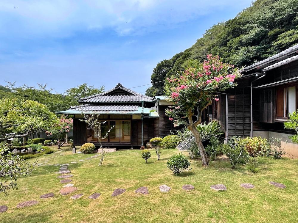 葉山町上山口の売買物件/敷地東側から南棟を見る｜右側（北側）は山の緑に守られている