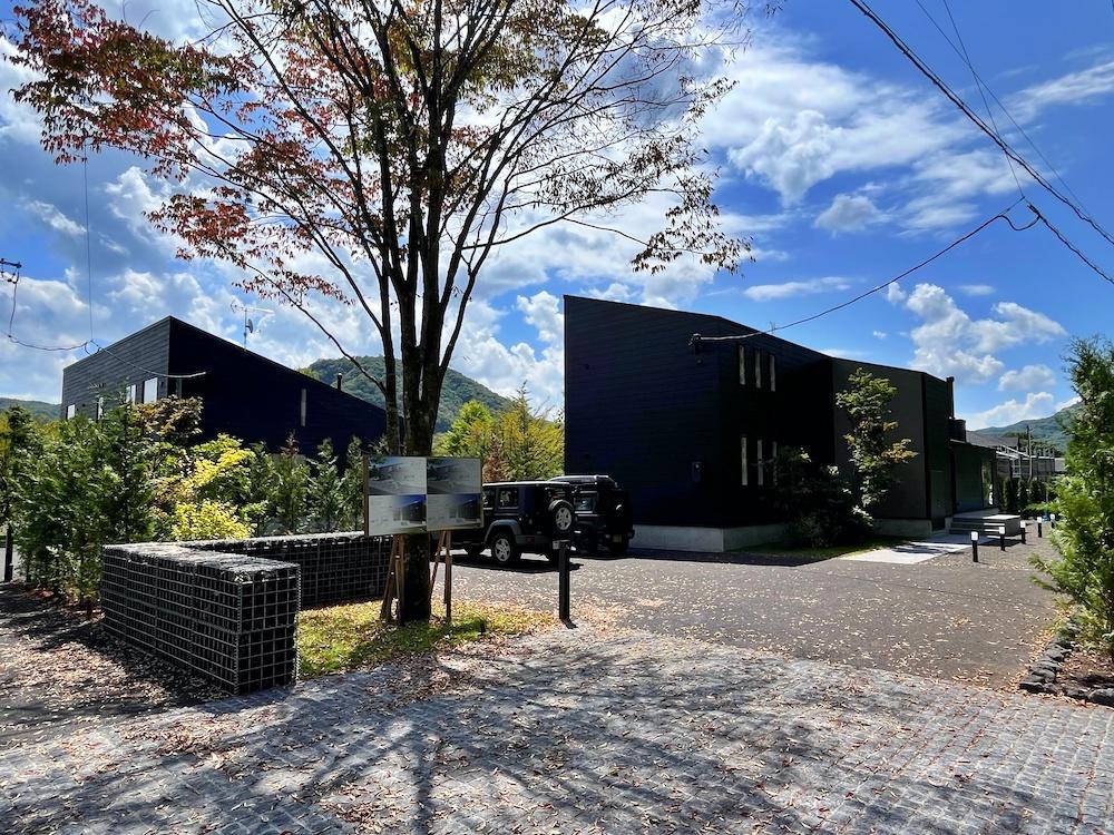長野県北佐久郡軽井沢町の売買物件/外観｜A,Bの2棟はシンボルツリーや腰高まで石積みでゆるやかな境目をつくることで、一体となった風景を作り出している。