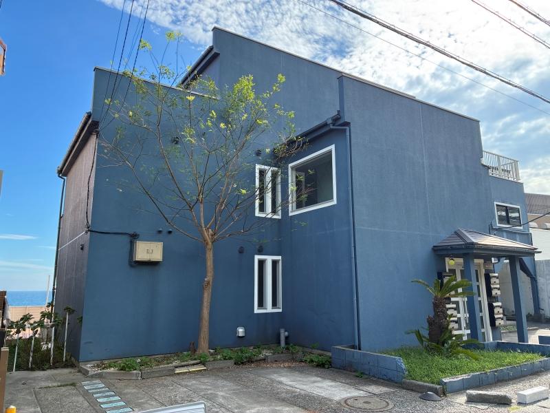 鎌倉市七里ガ浜一丁目の賃貸物件/外観｜線路側から見ると、建物の脇にチラッと海が。見た目は一戸建てですが、共同住宅です。
