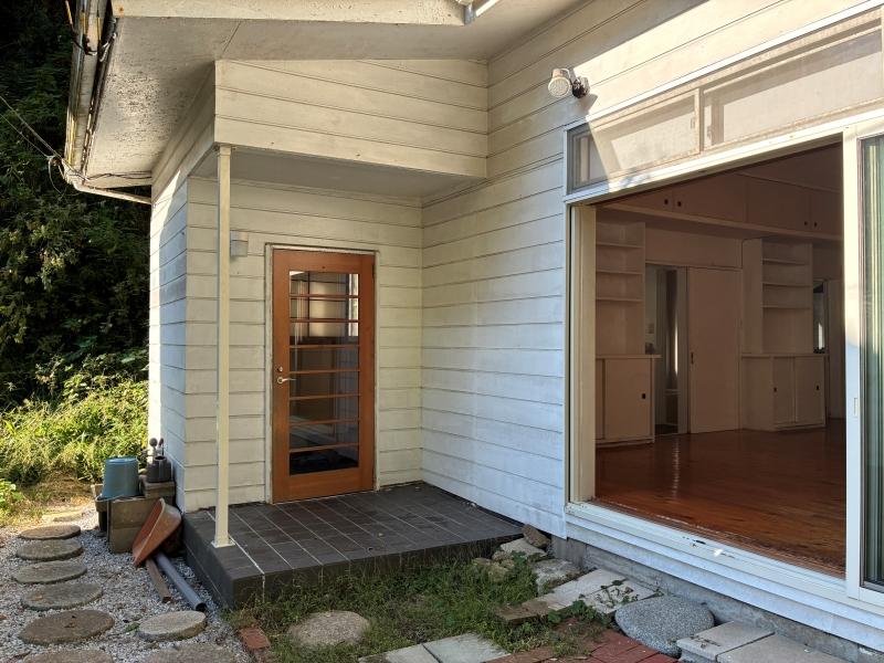 鎌倉市浄明寺四丁目の賃貸物件/外部|白い板張りの外壁にちょこんと見える茶色の玄関扉