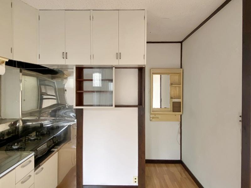 逗子市小坪五丁目の賃貸物件/キッチン│ガラス戸の収納がかわいい。廊下を進むと浴室です。