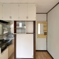 逗子市小坪五丁目の賃貸物件/キッチン│ガラス戸の収納がかわいい。廊下を進むと浴室です。