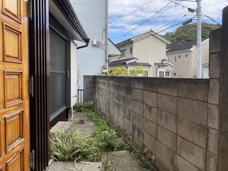 逗子市小坪五丁目の賃貸物件/建物とレンガ壁の間のスペース