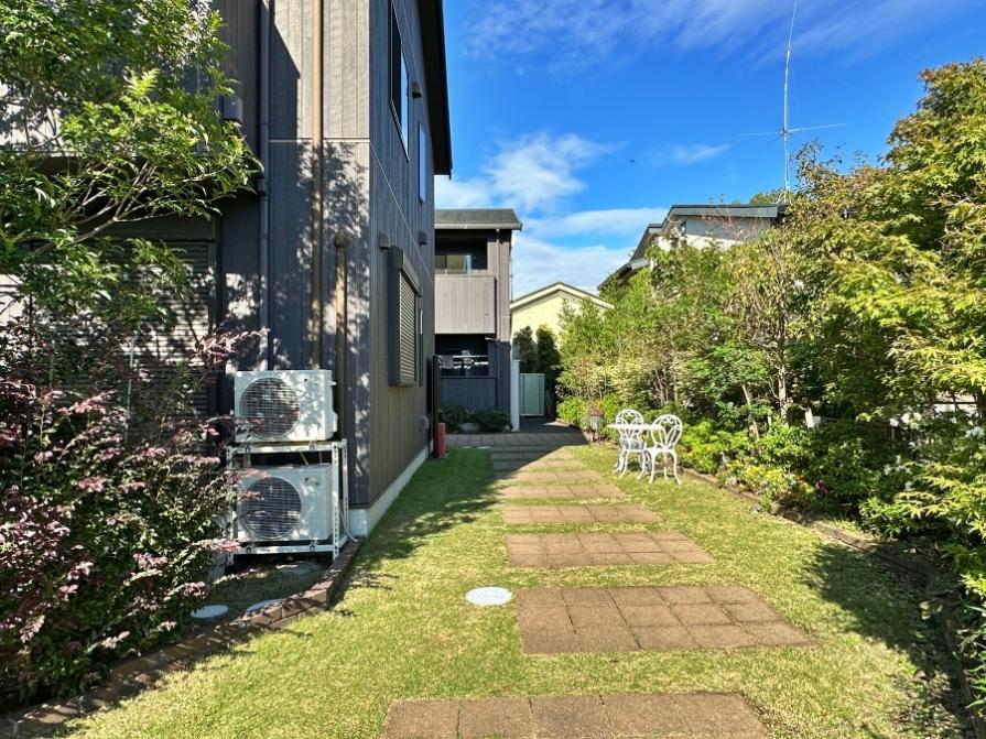 鎌倉市扇ガ谷一丁目の賃貸物件/玄関までのアプローチ｜芝生と植栽と石畳とガーデニングチェア