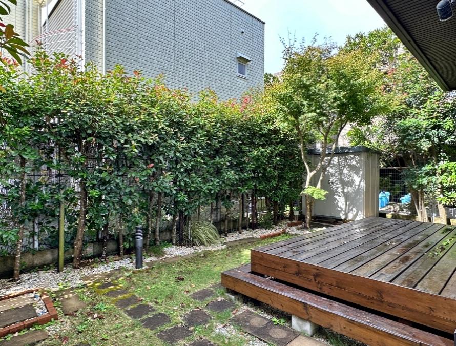 鎌倉市笹目町の賃貸物件/ウッドデッキと庭｜写真左隅に温水の外シャワー。植栽もあってなんとなくおこもり感があります