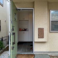 鎌倉市台の売買物件/玄関ドア右の茶色い扉はちょっとした物入れ。昔なら牛乳受け？