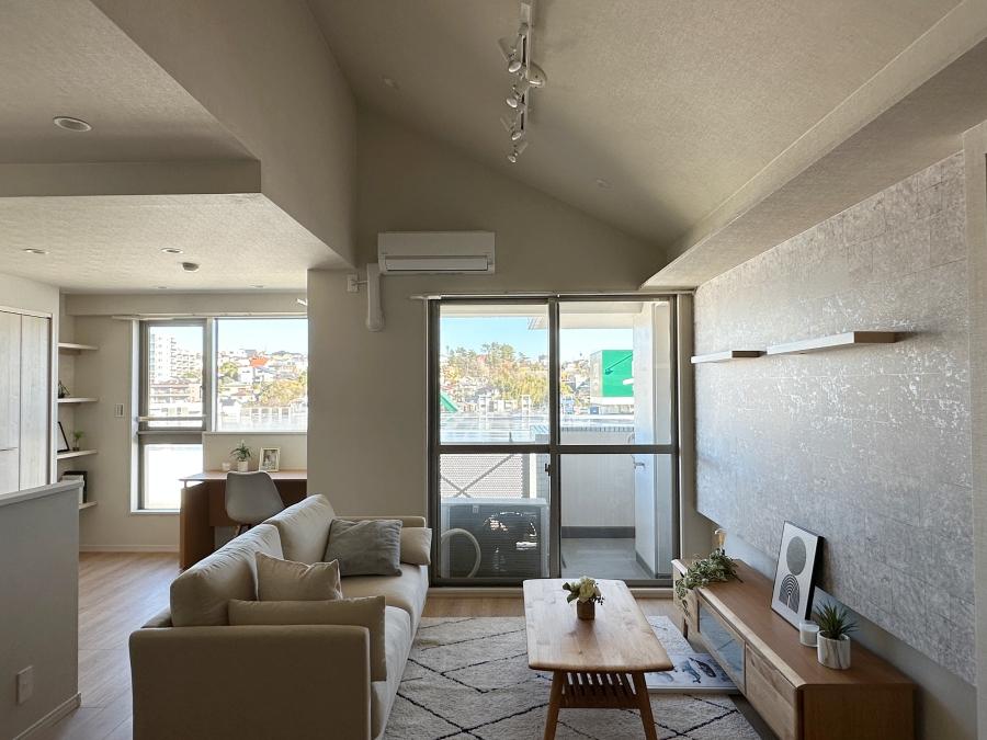 藤沢市善行坂一丁目の売買物件/ダイニングで立った時の目線｜窓の先に緑と高台の家並みが広がっていますが、手間にはスーパー屋上の無機質なソーラーパネル