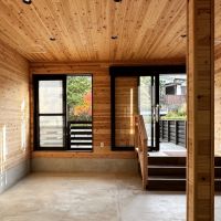 鎌倉市山ノ内の賃貸物件/店内｜壁沿いにはヴィンテージの黒い皮張りベンチソファとテーブルのかわりに少し背の高い酒樽をいくつか