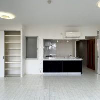 逗子市小坪五丁目の売買物件/LDK別角度│引き戸の収納棚が2つ、キッチン作業台の手前(黒い扉)も収納棚