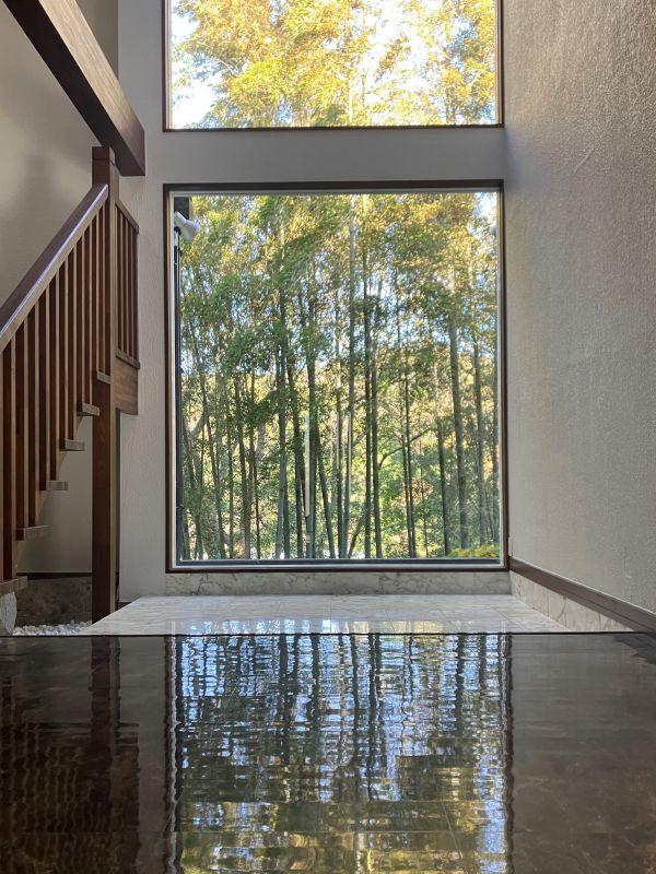 鎌倉市津の売買物件/ホール｜玄関を入ると、絵画のような竹林が正面に。贅沢を言うなら、黒い部分の床材を本物の石材に変えてみたい。