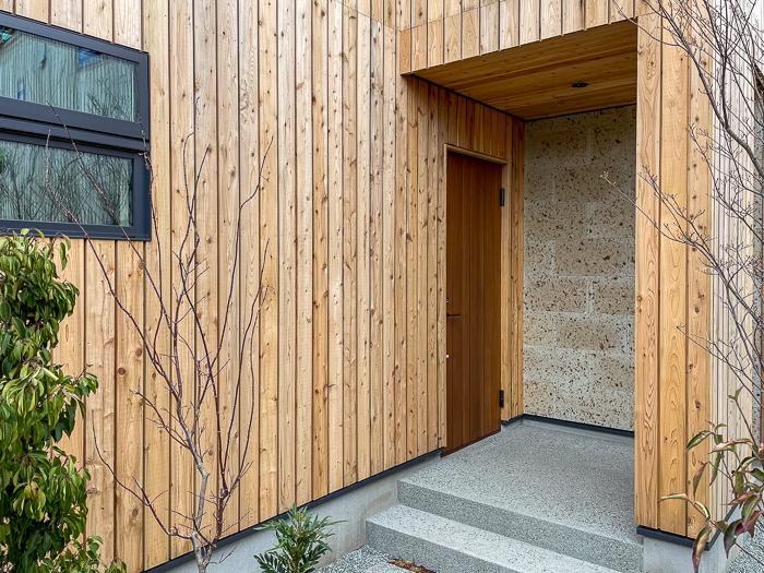 鎌倉市梶原二丁目の売買物件/玄関のアプローチは洗い出しの仕上げと杉板と大谷石の組み合わせ。豊かな感じです