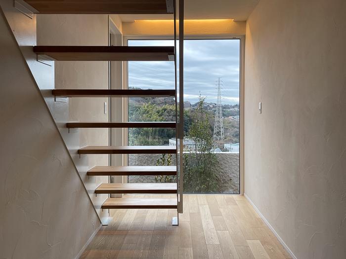 鎌倉市梶原二丁目の売買物件/玄関を入ると正面にフィックスの窓。南側の眺望を楽しみつつ2階に登ります