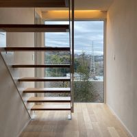 鎌倉市梶原二丁目の売買物件/玄関を入ると正面にフィックスの窓。南側の眺望を楽しみつつ2階に登ります