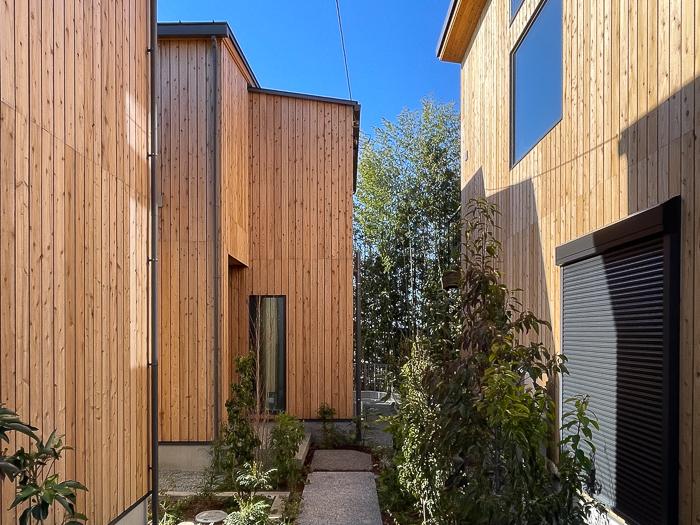 鎌倉市梶原二丁目の売買物件/杉板壁に囲まれたアプローチからB号棟を見る