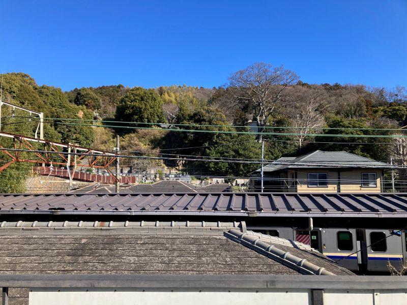 鎌倉市山ノ内の賃貸物件/バルコニーからの眺望｜中央の屋根は駅のホームの屋根です。その向こうに、お寺の山が見えます。