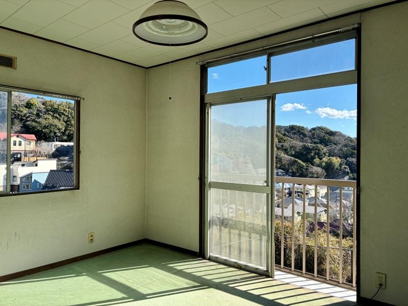 逗子市山の根二丁目の売買物件/2階 洋室2｜緑のマットが敷かれていますが、剥がして好みの床材に。窓枠、巾木と揃えて濃い茶色のフローリングが合いそう