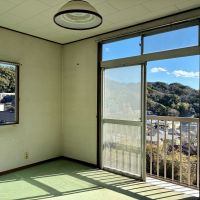 逗子市山の根二丁目の売買物件/2階 洋室2｜緑のマットが敷かれていますが、剥がして好みの床材に。窓枠、巾木と揃えて濃い茶色のフローリングが合いそう