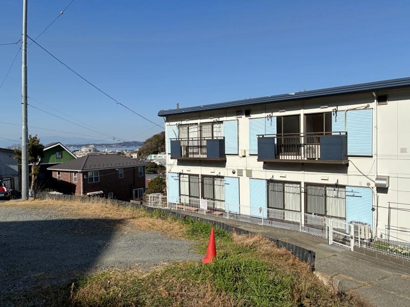 葉山町堀内の賃貸物件/駐車場｜アパートの奥に海がチラッと見える素敵な駐車場
