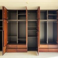 藤沢市辻堂太平台一丁目の賃貸物件/洋室１｜壁面いっぱいに木製の収納棚が構えています。所々日に焼けた木目の表情がいい感じ