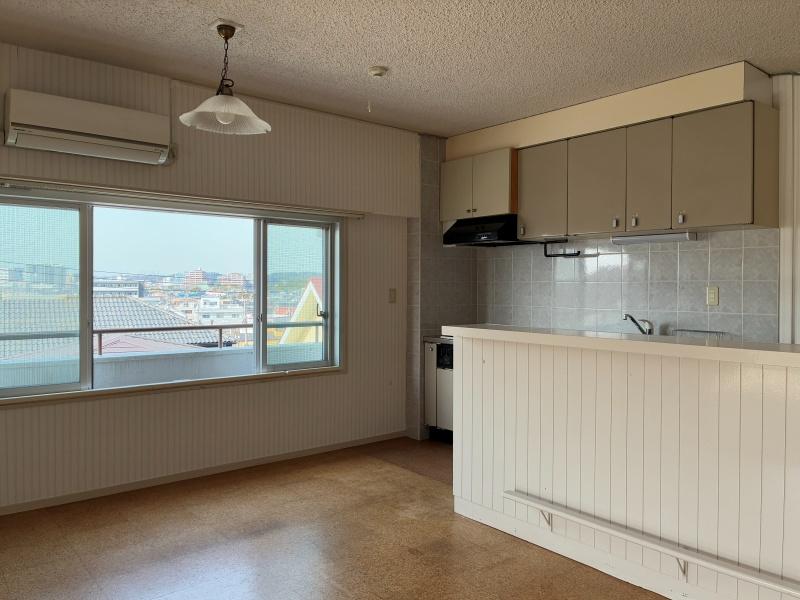 藤沢市辻堂太平台一丁目の賃貸物件/LDK｜ストライプ柄の壁紙とペンダントライトがレトロな印象。大きな窓の向こうには遠くまで抜ける空。コルク材の床も時間を重ねて良い味わいです