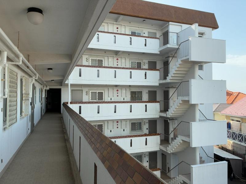 藤沢市辻堂太平台一丁目の賃貸物件/外廊下｜深みのある赤レンガと白い塗装が、少しだけ洋風感を醸し出しています。レトロなヴィラに遊びにきたよう