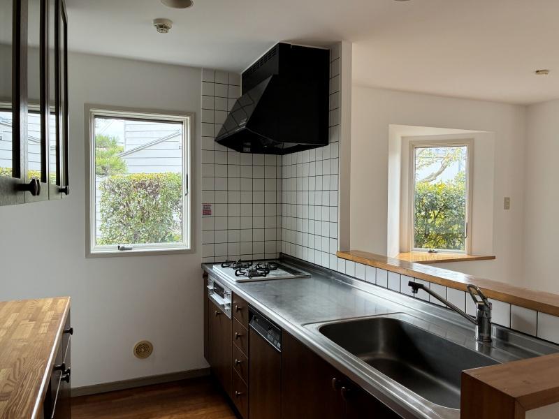 藤沢市片瀬海岸三丁目の賃貸物件/キッチン｜木製の食器棚とタイルがレトロで可愛らしい。3口ガスコンロと食洗器が付いています