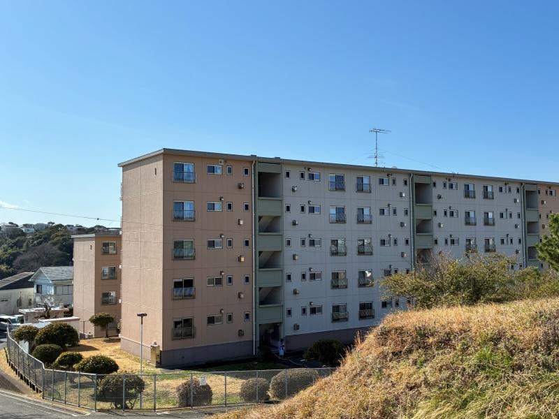 逗子市小坪二丁目の売買物件/外観｜ハゲ山から見た小坪ハイツ。アイボリー、ピンク、グリーンとやわらかい色使い