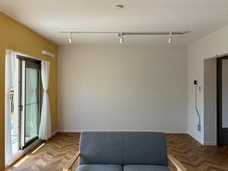 逗子市小坪二丁目の売買物件/リビングダイニング｜反対から見て。床はヘリンボーン柄、壁の一部は塗り壁です。コンクリートの凸凹感をあえて残し、ラフな表情に