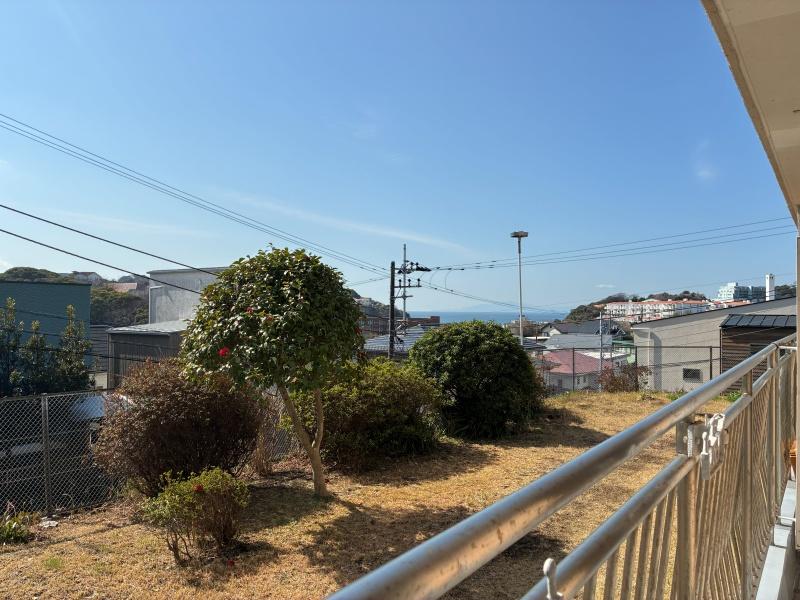 逗子市小坪二丁目の売買物件/バルコニー｜1階の部屋でも十分海見え！右奥には異国感あるコスモミロス逗子も。バルコニーは横長につながっています