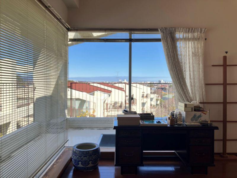 平塚市唐ケ原の売買物件/LD｜北西側の窓ガラス。見えるのは家々の屋根と青い空。