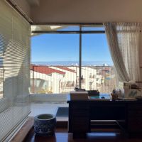 平塚市唐ケ原の売買物件/LD｜北西側の窓ガラス。見えるのは家々の屋根と青い空。