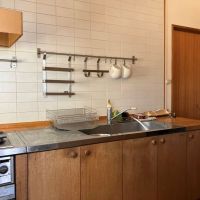 平塚市唐ケ原の売買物件/キッチン｜ステンレスと木製の天板に、前面の壁は白いタイル。背面にはカップボードがあり収納も十分。