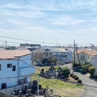 藤沢市本鵠沼四丁目の賃貸物件/バルコニーからの眺め│屋根の連なりの向こうに江ノ島が見えます